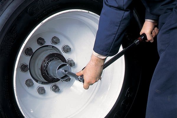 Someone tightening a lug nut.